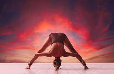 a woman in full dawn of strength, a little over forty, performs exercises from yoga. a woman has...