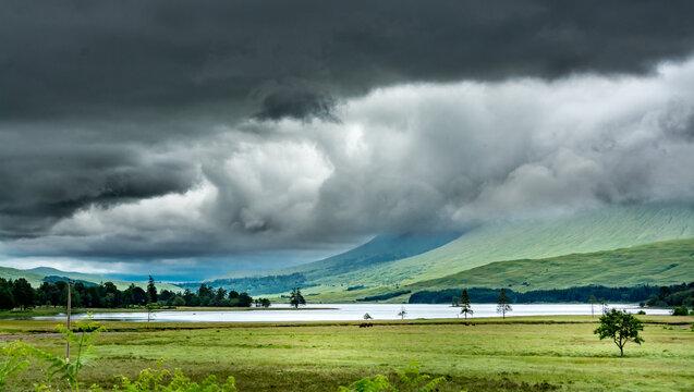 Landscape along the West highland Way in Scotland. Large black clouds laden with rain roll over Loch Tulla.