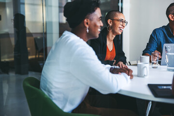 Fototapeta premium Businesspeople smiling during their morning meeting in an office