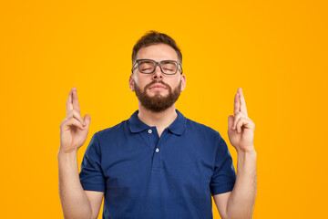Bearded man with crossed fingers making wish