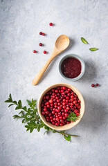 juicy forest lingonberry with handmade jam  in a wooden bowl on white table. Concept homemade healthy food. Top view and copy space