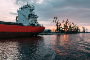 Obraz premium Ship cargo crane port. Container loading industry. Trade and import global transportation by sea ships. Export logistic industry. Cargo sea harbor at evening
