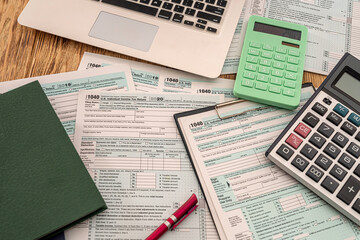 Obraz premium on wooden table are tax forms 1040, calculator, laptop pen notebooks