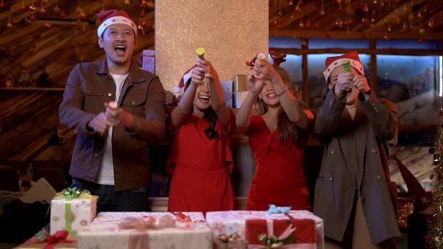 Party of beautiful asian friend young teen countdown and shooting paper flares. female and male celebrating. happiness friends meeting for Happy New Year culmination and christmas eve theme.