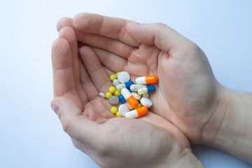 a lot of pills and tablets in the hand, consuming a lot of pills concept
