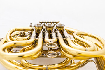 A shiny lacquered French horn on a white background