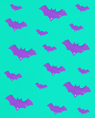 Flying bat wings silhouettes. Purple paint on green canvas. Halloween holiday poster concept and greeting card. Minimalistic spooky flat lay composition.