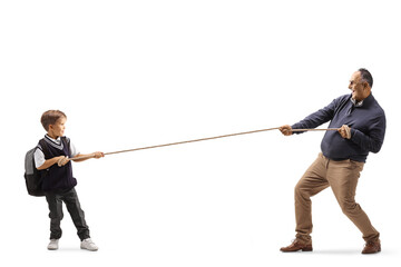 Full length profile shot of a little schoolboy and an elderly man pulling a rope