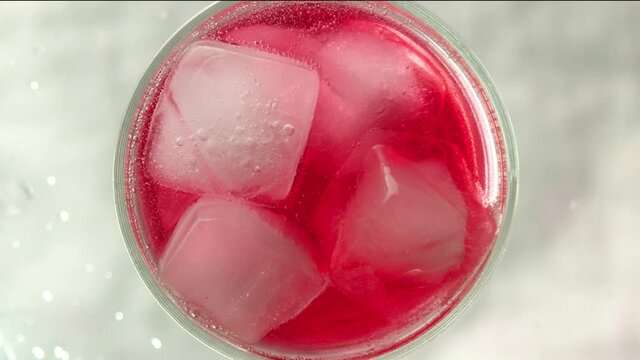 Raspberry lemonade in a glass with ice bubbles