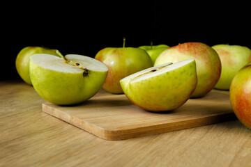 Fresh delicious apples on a wooden board and kitchen table. Healthy diet food fruits composition.