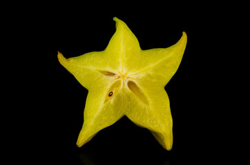 Carambola (star fruit or 5 fingers). Star-shaped slice of fresh and delicious Averrhoa carambola on black background.