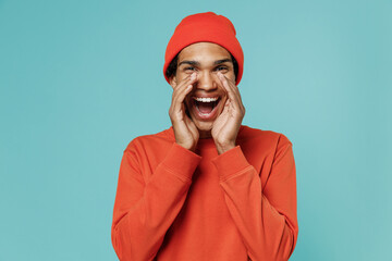 Young promoter african american man in red shirt hat scream hot news about sales discount with hands near mouth isolated on plain pastel light blue background studio portrait People lifestyle concept