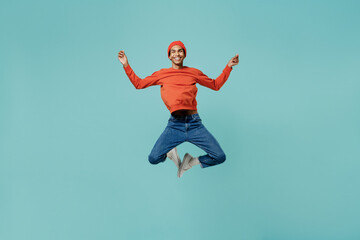 Fototapeta na wymiar Full body young happy african american man in orange shirt hat hold spread hands in yoga om aum gesture relax meditate try calm down jump high isolated on plain pastel light blue background studio.