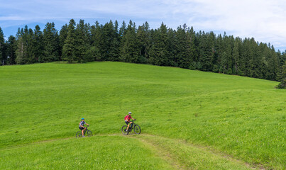 Obraz premium nice and remained young grandmother and her grandson riding their electrc mountain bikes in the Allgaeu Alps near Oberstaufen in Bavaria, Germany