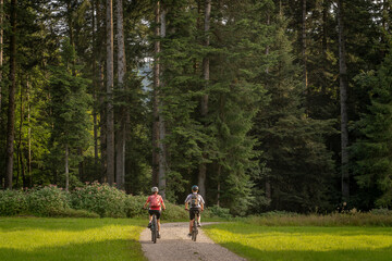 nice and remained young grandmother and her grandson riding their electrc mountain bikes in the...