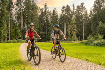 Naklejka premium nice and remained young grandmother and her grandson riding their electrc mountain bikes in the Allgaeu Alps near Oberstaufen in Bavaria, Germany