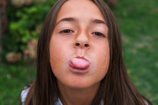 Young girl with funny expression. Tongue out of mouth