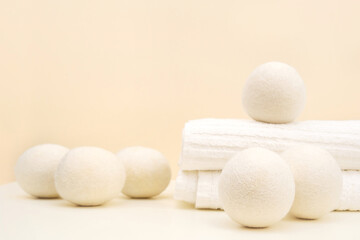 Wool Dryer Balls On White Towel On Beige Background. Eco Friendly Laundry Supplies. Alternative...