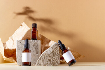 Face and body skin care products in a glass bottle with a pipette on a background of geometric...