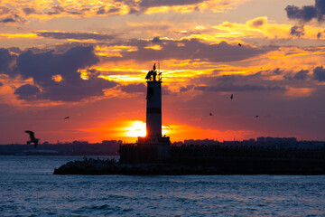 lighthouse and breakwater view. dramatic sunset. kadikoy, istanbul, turkey.
