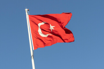 Waving flag of Turkey on a background of blue sky.