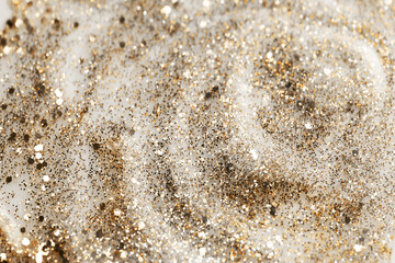 Shiny gold glittering background with soft selective focus. Nail polish texture.