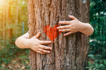 Tree embracing, a young girl hugging a tree with a red heart as a symbol of love for nature....
