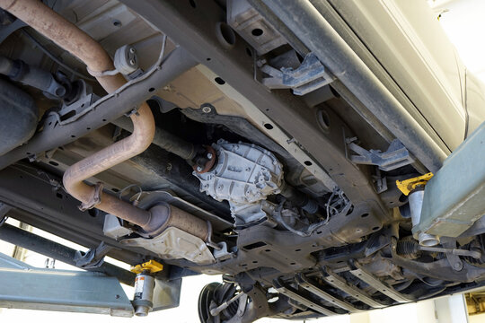 Modern car in a car service on a lift. Transfer case, muffler, exhaust pipe. Car service and repair.