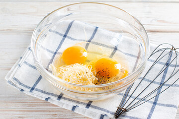 Making omelets, fresh raw eggs in a glass bowl on the table