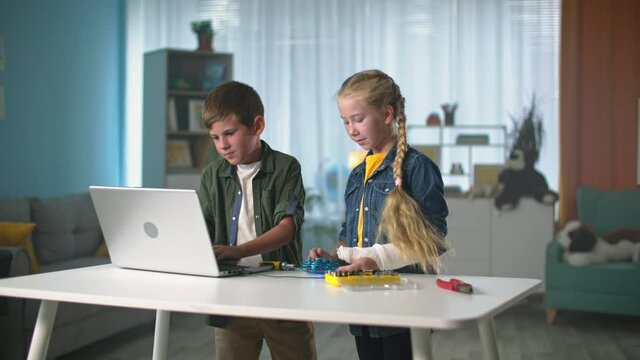 self-development, children study the work of a mini quadrocopter connected to laptop while standing at the table