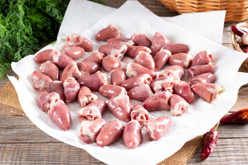 Raw chicken hearts on wooden background. Concept of healthy eating
