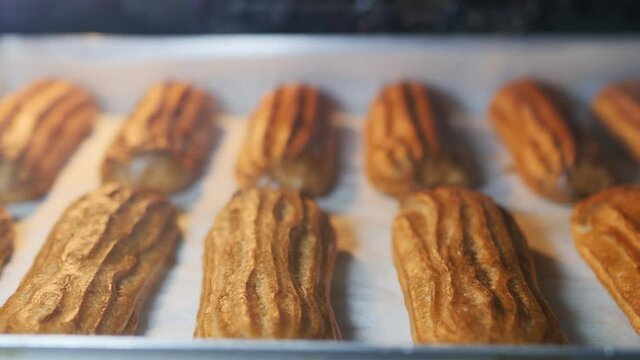 DOF, Dolly shot: French custard eclairs are oven-baked until golden brown. We prepare eclairs according to a traditional recipe at home.