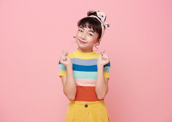 Happy asian girl hand showing mini heart gesture over pink background..