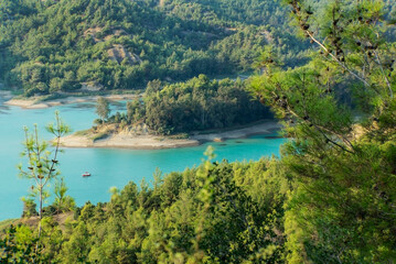 Beautiful green lake among mountains in forest on a sunny day,  landscape photography