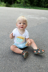 little smiling happy blond child playing in the park