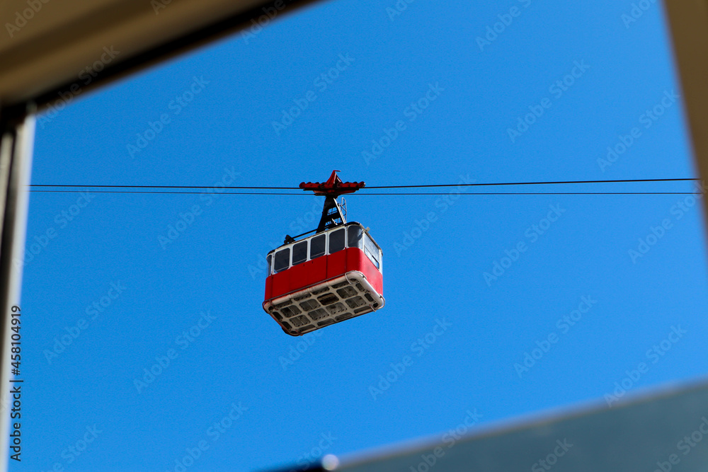 Wall mural old vintage red cable car cabin in the bright blue sky