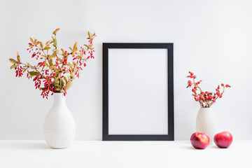 Home interior with decor elements. Mockup with a black frame, colorful autumn leaves and red...