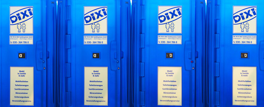 Berlin, Germany - June, 2020: Portable street WC toilet cabins in a park. Line of chemical, public toilets