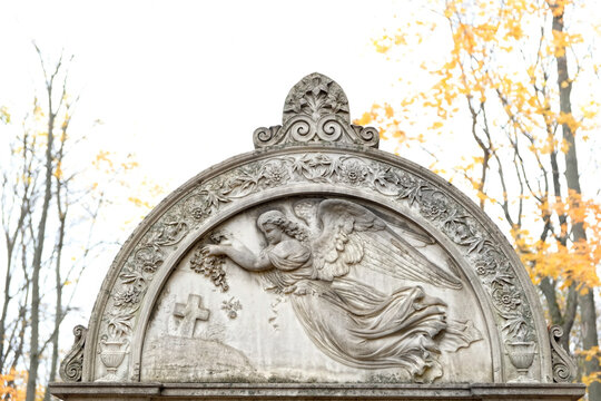 old gravestone with angel image on cemetery, autumn natural background. Design for condolences, mourning cards or obituary. concept of religion, faith, Remember, mourn, memory
