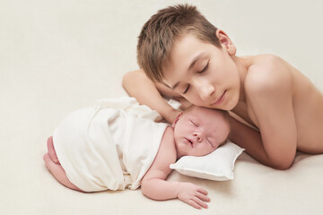 Obraz na płótnie Canvas Newborn baby boy with older brother sleeping on white background. Medicine and health concept, happy motherhood and fatherhood. Maternity hospital and clinic. Father and mother day