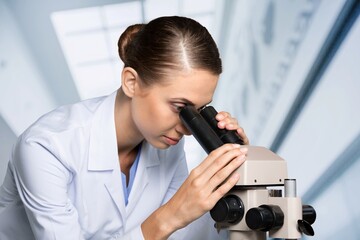 Fototapeta premium Scientist woman doctor analyzing test results using medical microscope