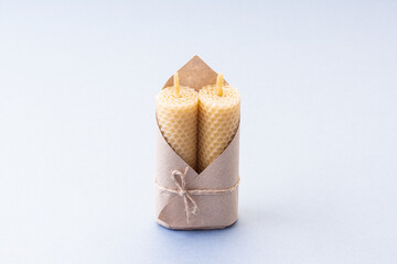 Two natural wax candles for interior on blue background. Handmade eco product. Eco-friendly gift. Horizontal