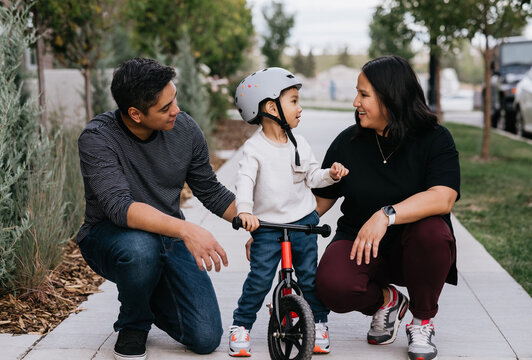 Parents teaching child how to ride bike