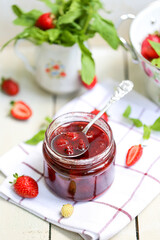 Homemade delicious strawberry jam and strawberry on a rustic table