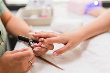 hispanic young female woman doing manicure with a Brazilian professional. fiberglass nail detail