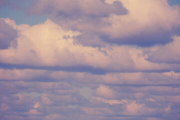 Fototapeta na wymiar Background of many fluffy clouds on the soft evening sky
