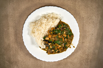 Rice with vegetable stew and sauce on the plate. Top view. 