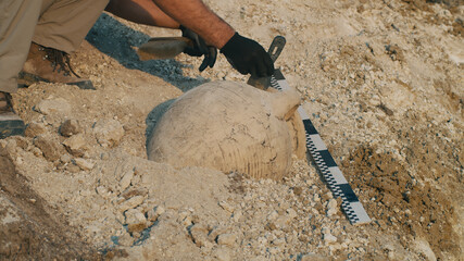 Crop man excavating old vase