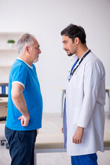 Obraz premium Old male patient visiting young male doctor