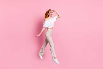 Full length body size view of attractive cheerful girl jumping looking way dream far isolated over pink pastel color background